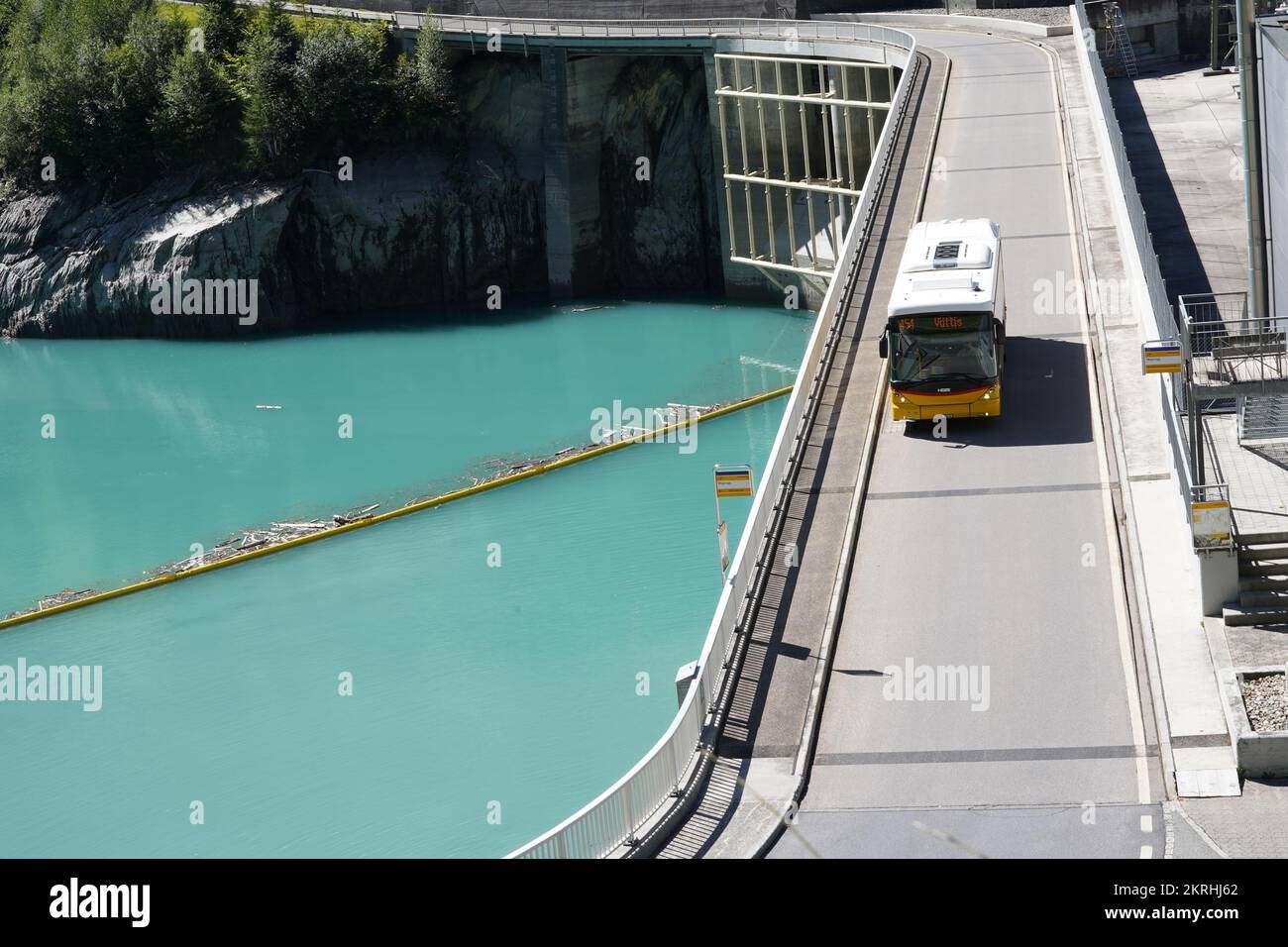 View on the bridge with yellow autobus of hydroelectric power plant on reservoir Mapraggsee. Stock Photo