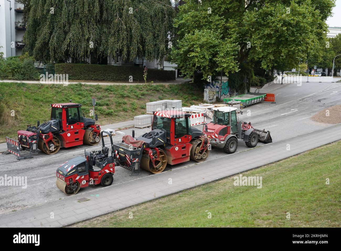 Red asphalt paving machines such as street rollers and wheel dozer. Stock Photo