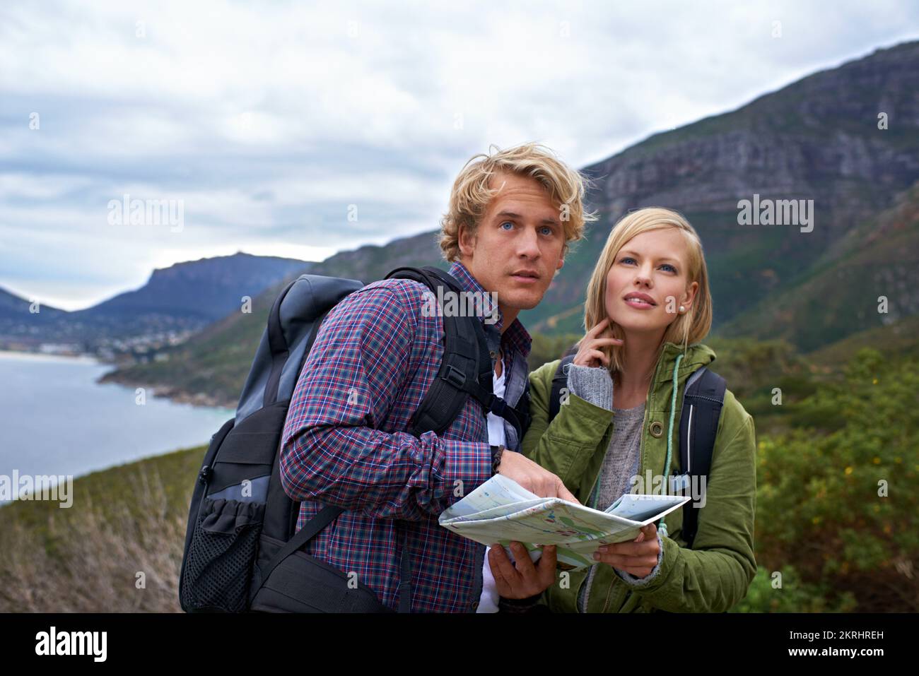 How do we get to the very top. Two backpackers with a map exploring nature. Stock Photo