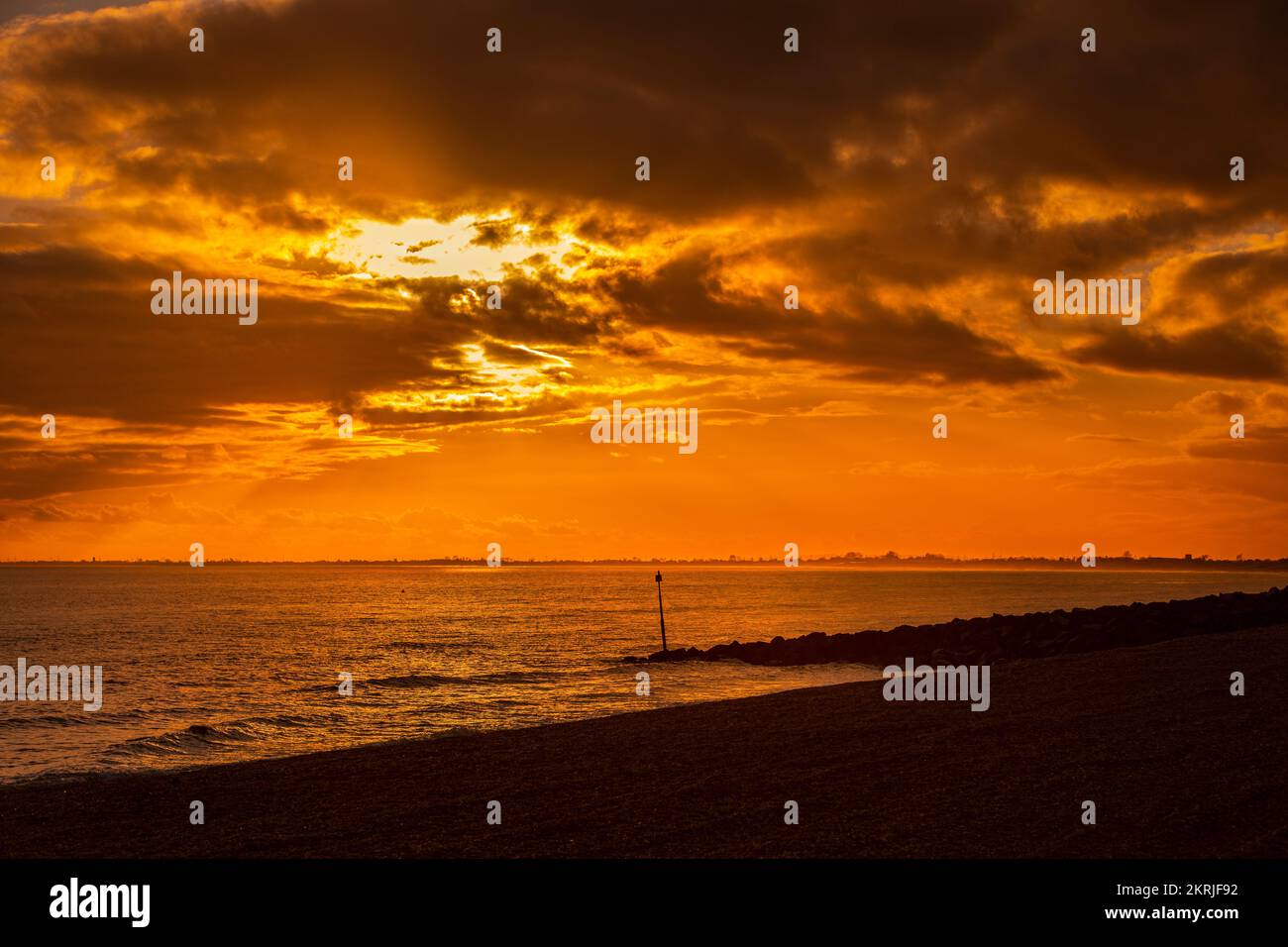 A golden sunset taken from Hythe beach, Kent. Stock Photo