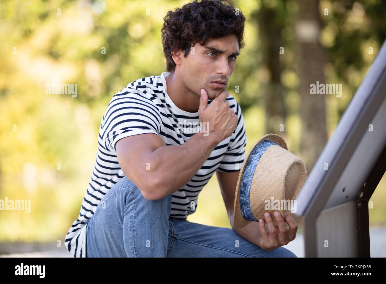 young man sitting and thinking in the forest Stock Photo - Alamy