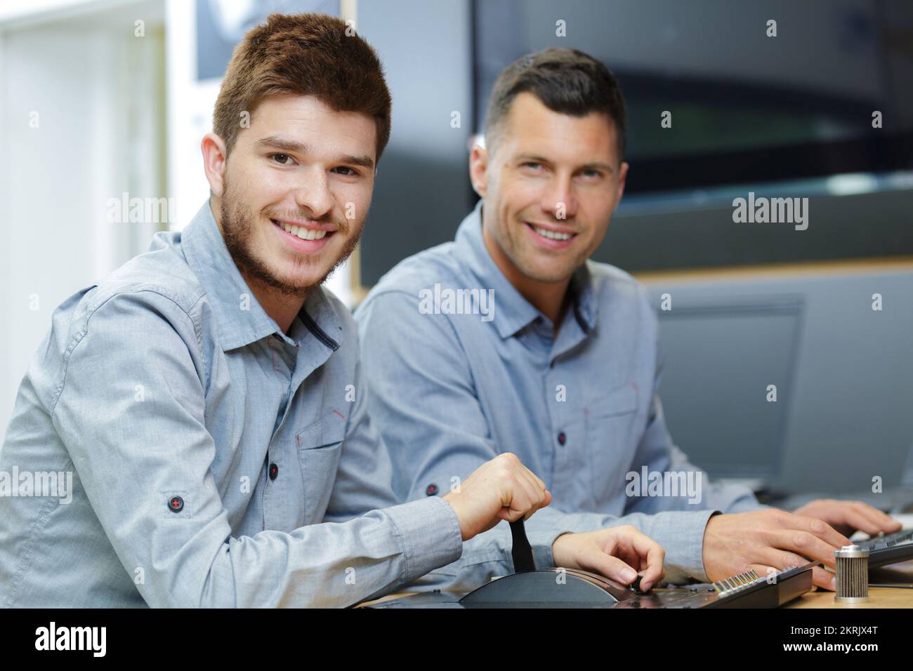 Two Guys Working two men working in flat screen television Stock Photo - Alamy