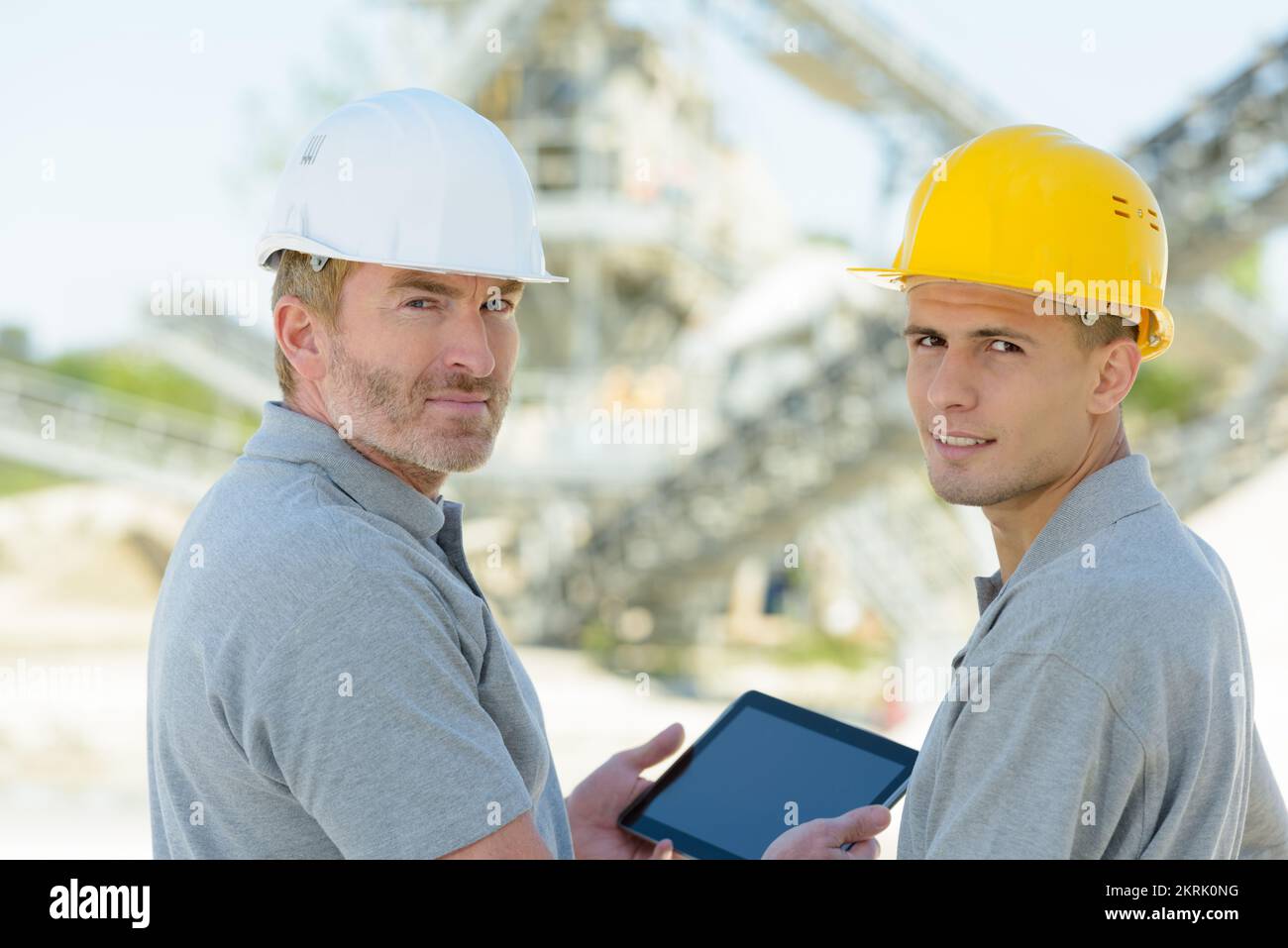 two engineers checking tablet outdoors Stock Photo - Alamy
