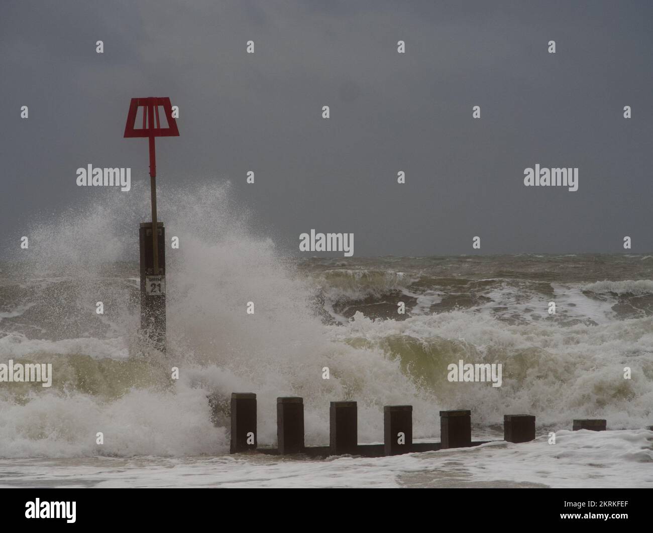 Winter waves splashing against groyne markers on Boscombe beach, Bournemouth Stock Photo