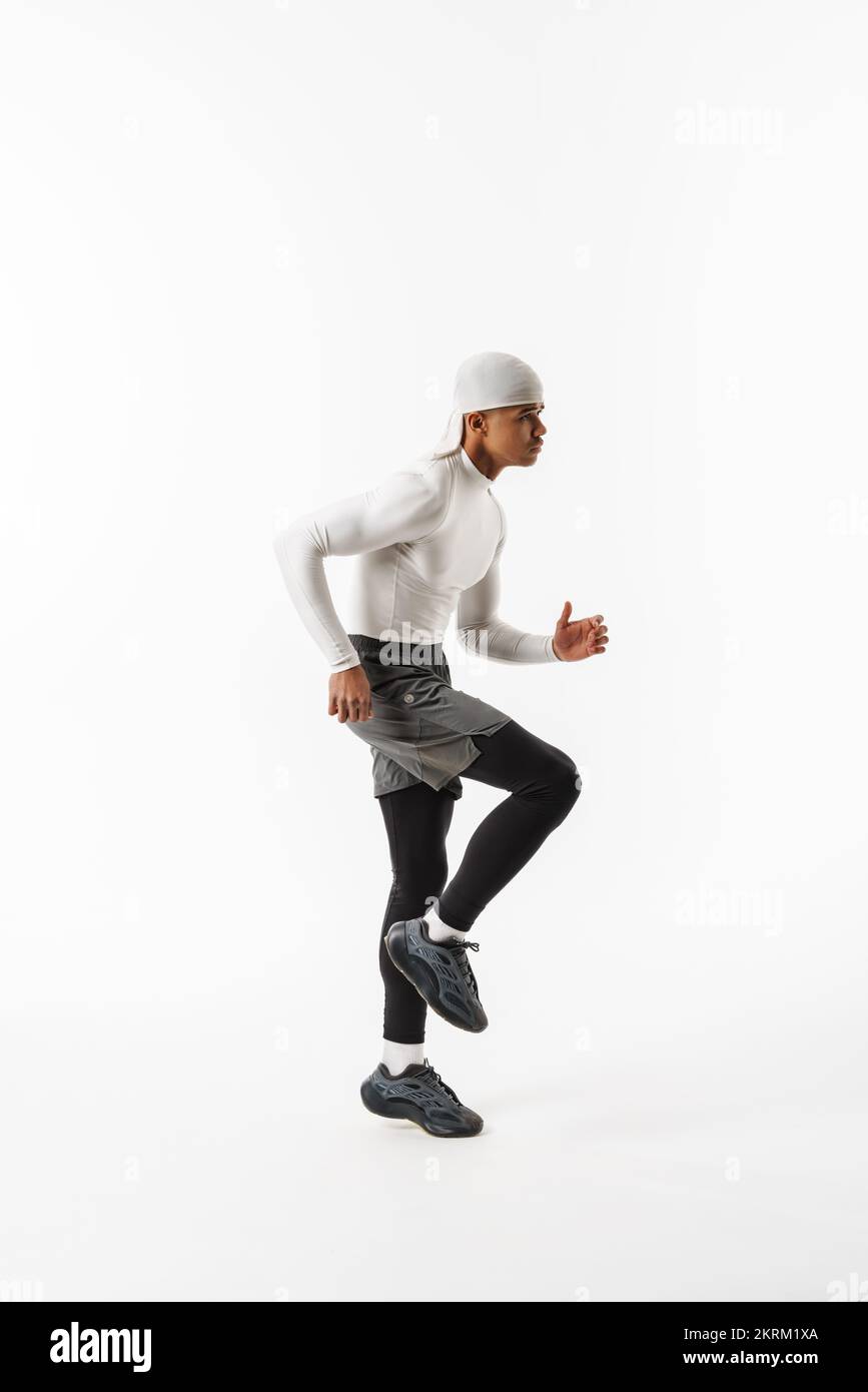 Young sportsman wearing bandana doing exercise while working out