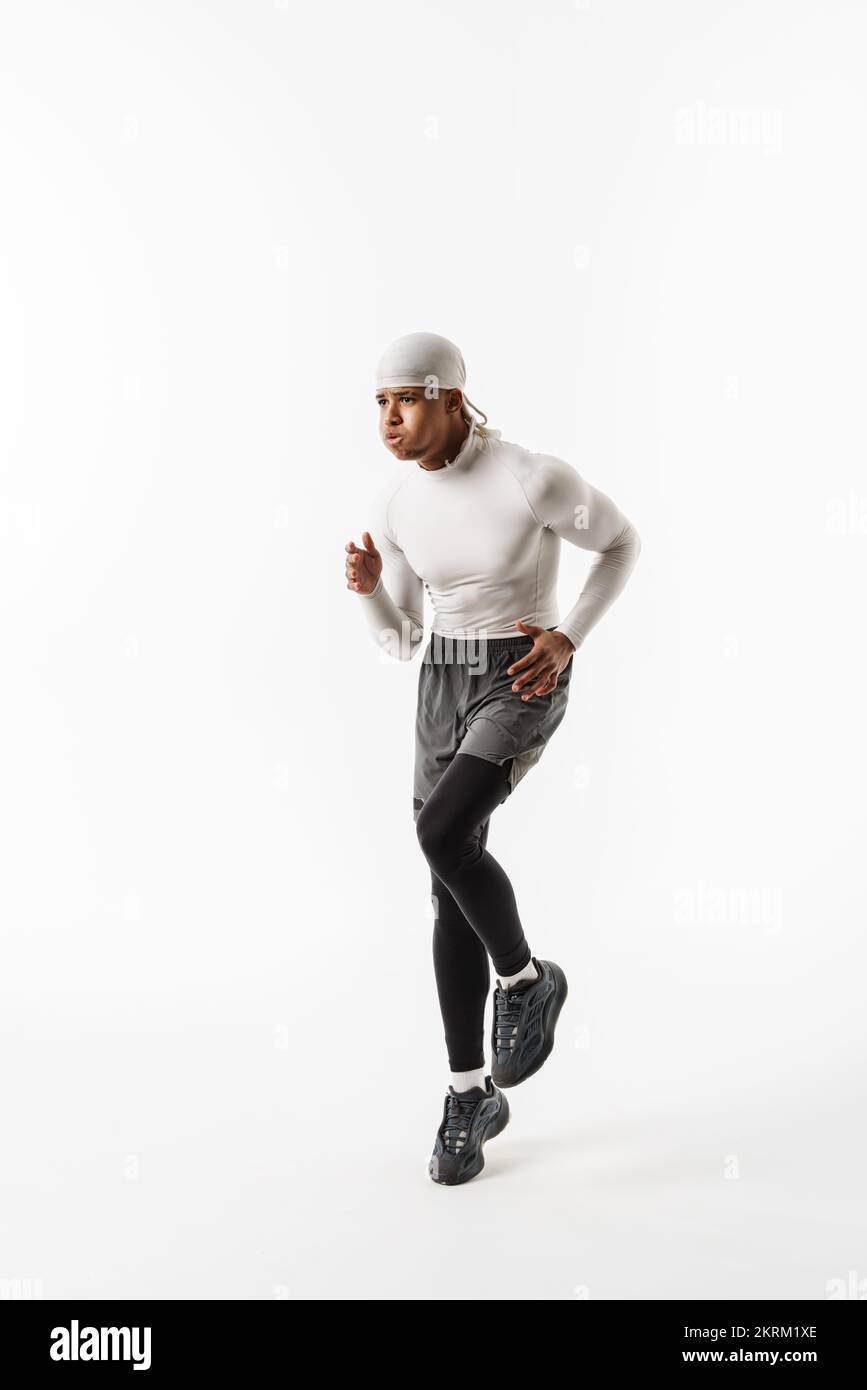 Young sportsman wearing bandana doing exercise while working out