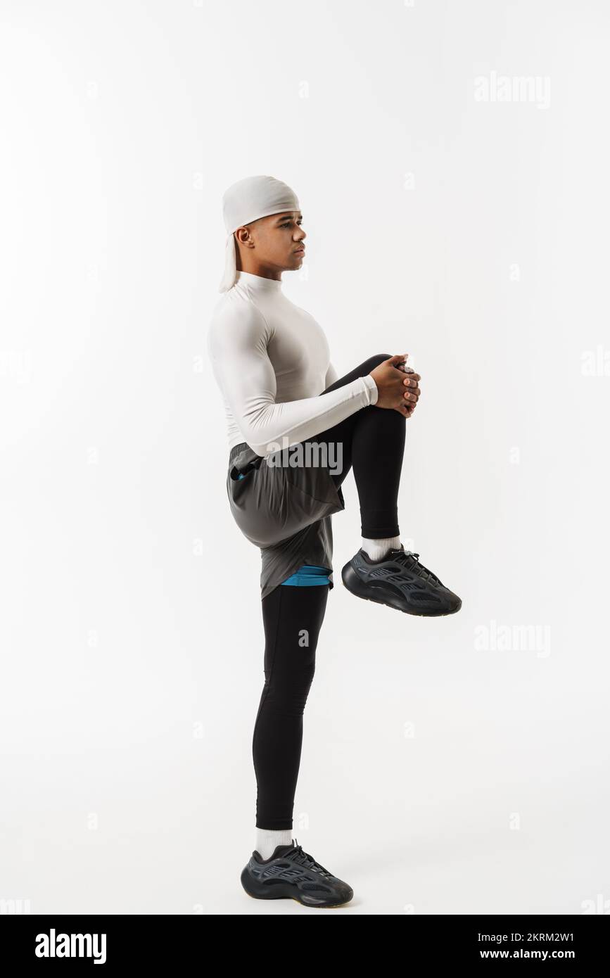Young sportsman wearing bandana doing exercise while working out