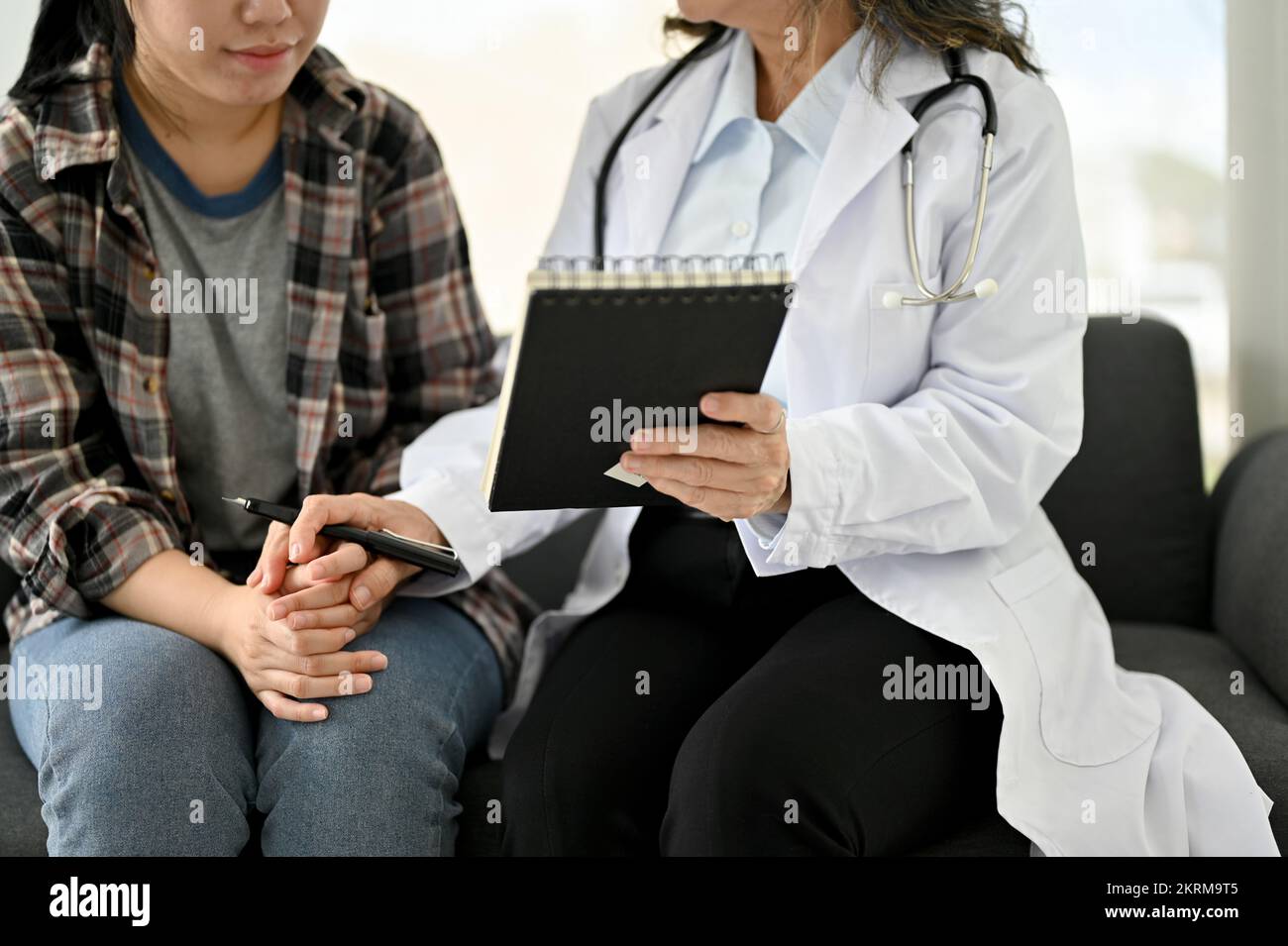 Professional Asian aged female doctor explained the treatment plan to her patient during the counseling. cropped image Stock Photo