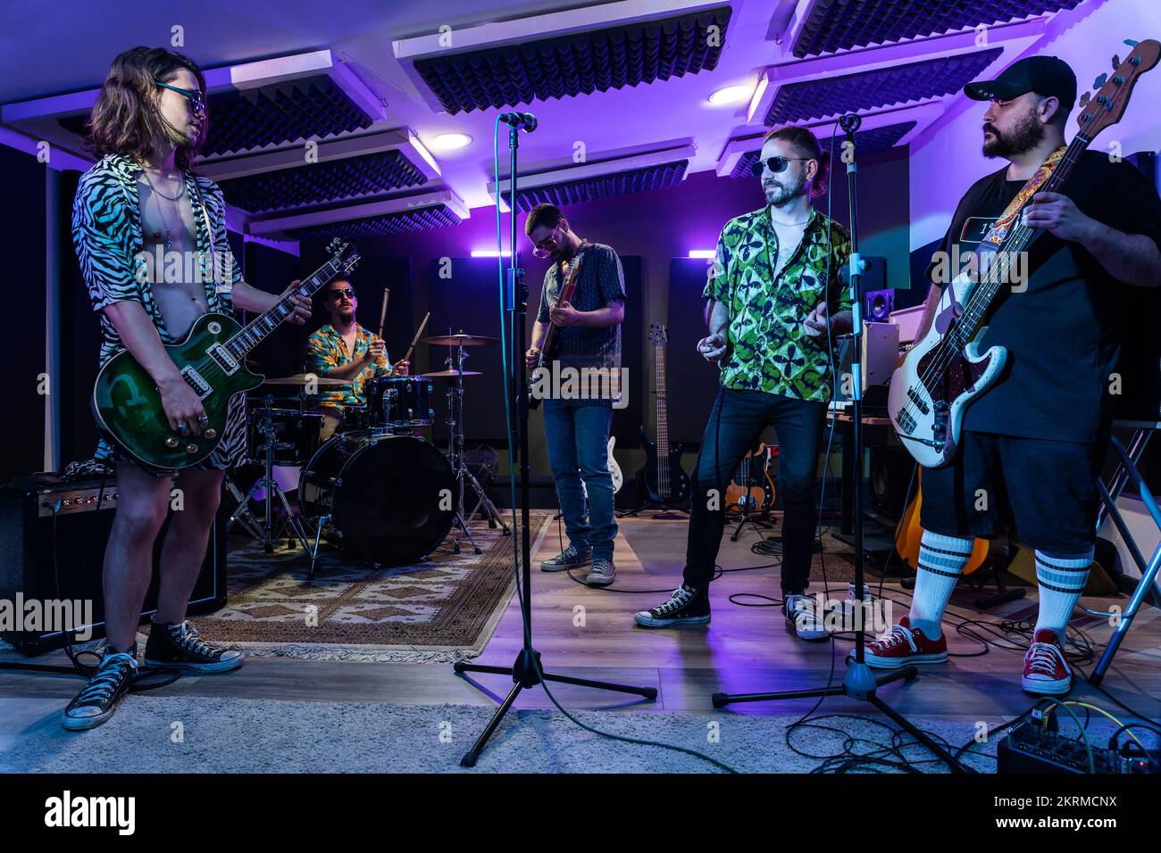 Group of musicians rehearsing song playing electric guitars and drums