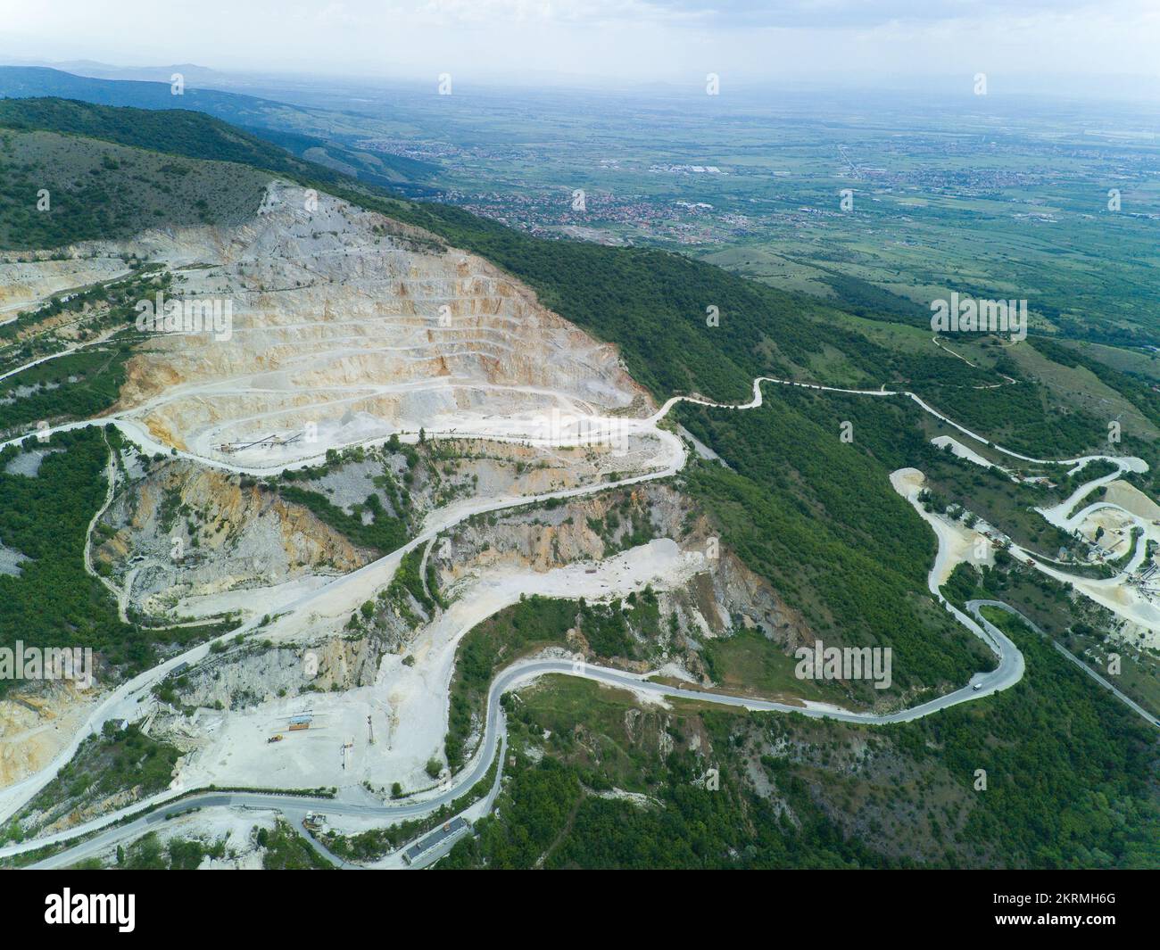 Mining with help of modern technology on slope of low mountain, in vegetal valley of Rhodope Mountains with forests and cloudy sky Stock Photo