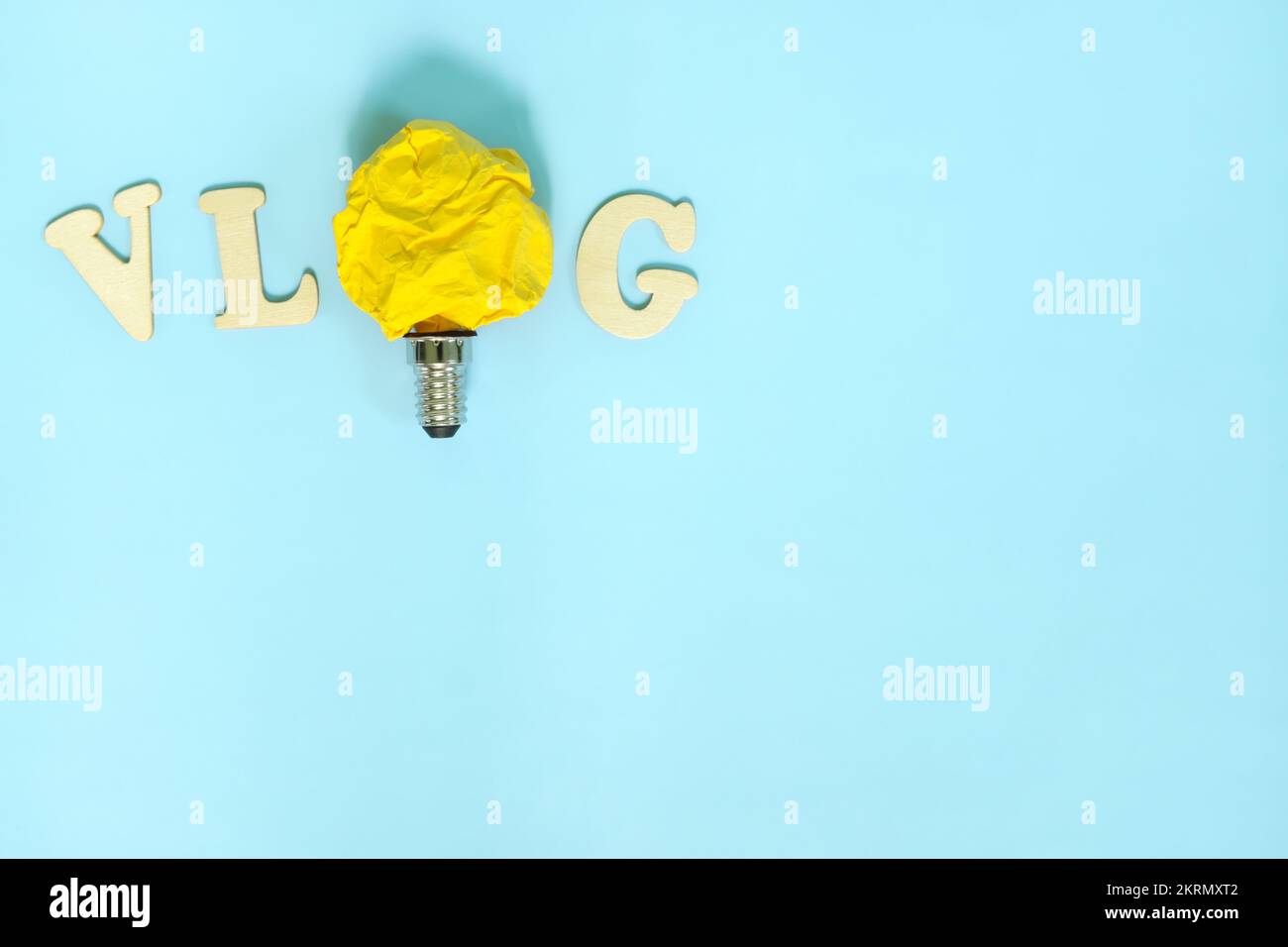 Vlog or vlogging video content innovative trends and ideas concept. Bright yellow crumpled paper light bulb. Stock Photo