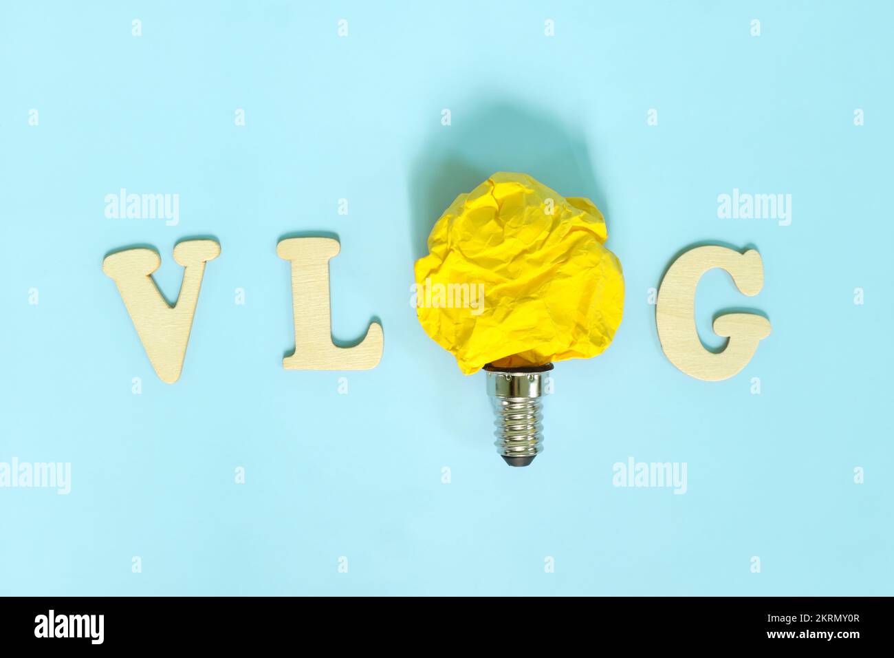 Vlog or vlogging video content innovative trends and ideas concept. Bright yellow crumpled paper light bulb. Stock Photo