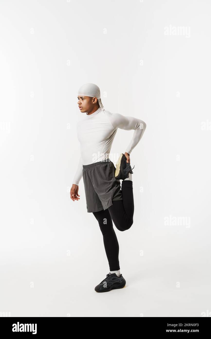 Young sportsman wearing bandana doing exercise while working out