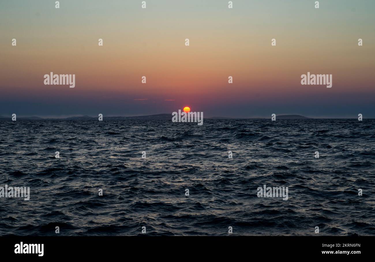 The sun going down on the horizon Stock Photo Alamy