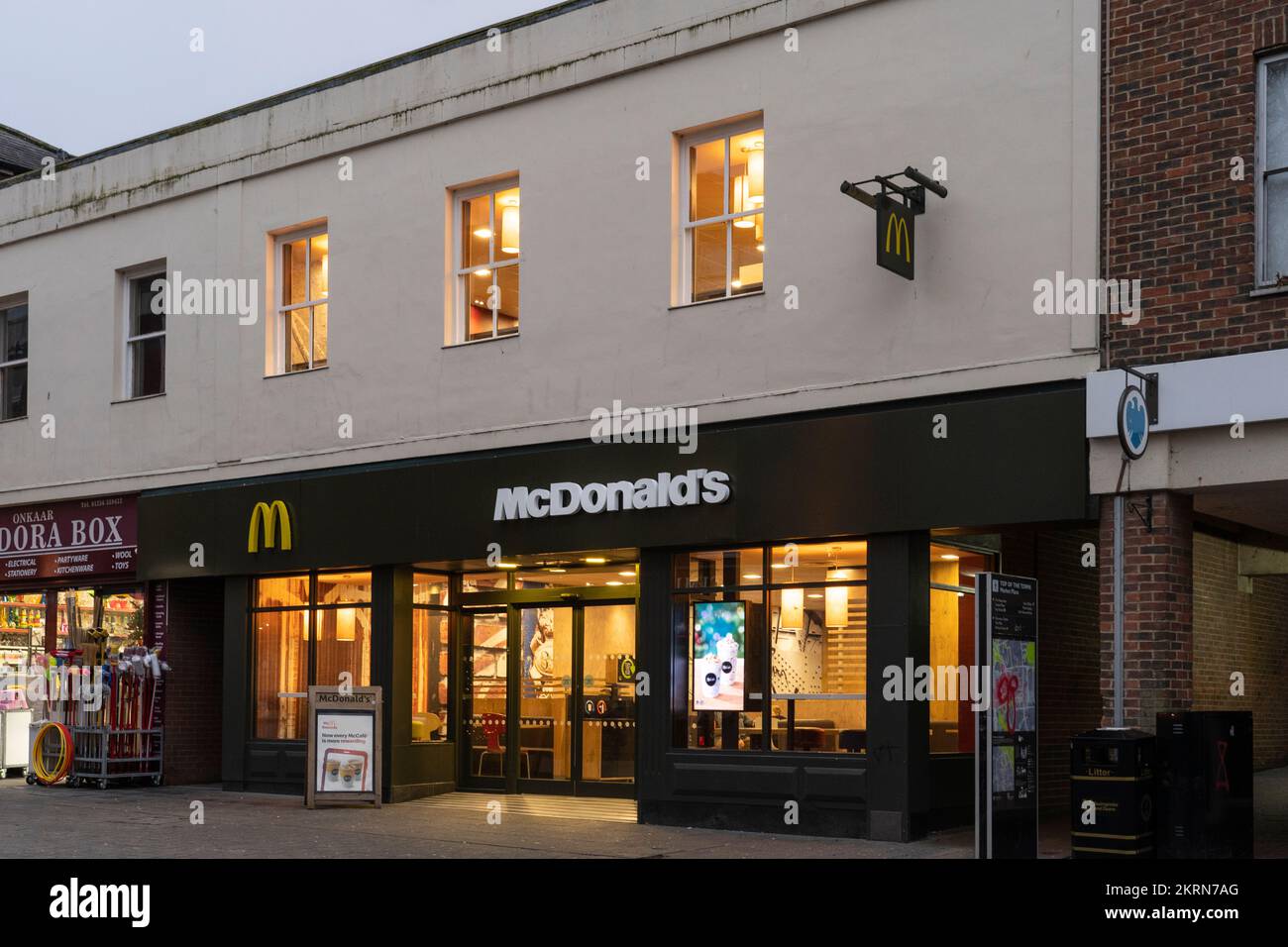 McDonald's restaurant at dusk on Market Place ('top of town'), Basingstoke, UK. Classic, long-running fast-food chain known for its burgers & fries Stock Photo