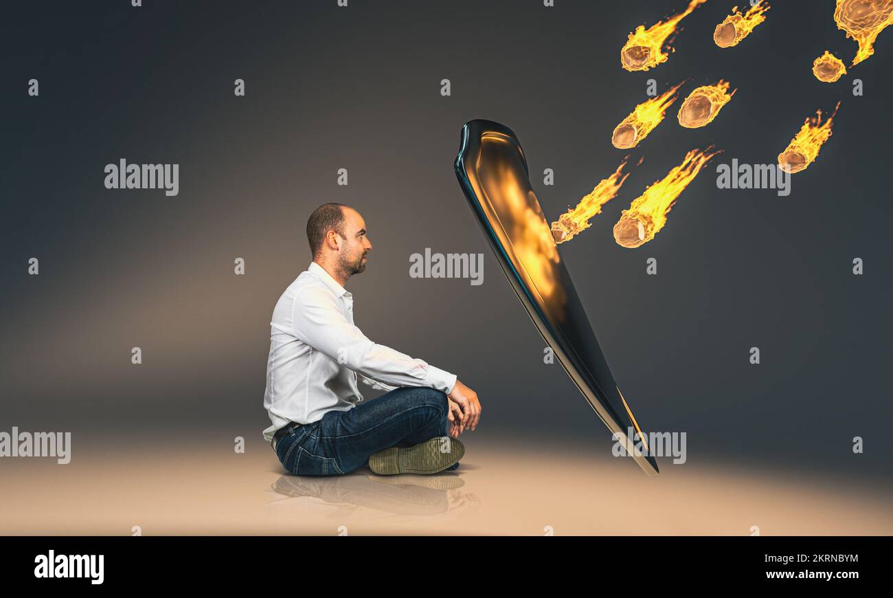 seated man protecting himself from danger with a metal shield Stock Photo