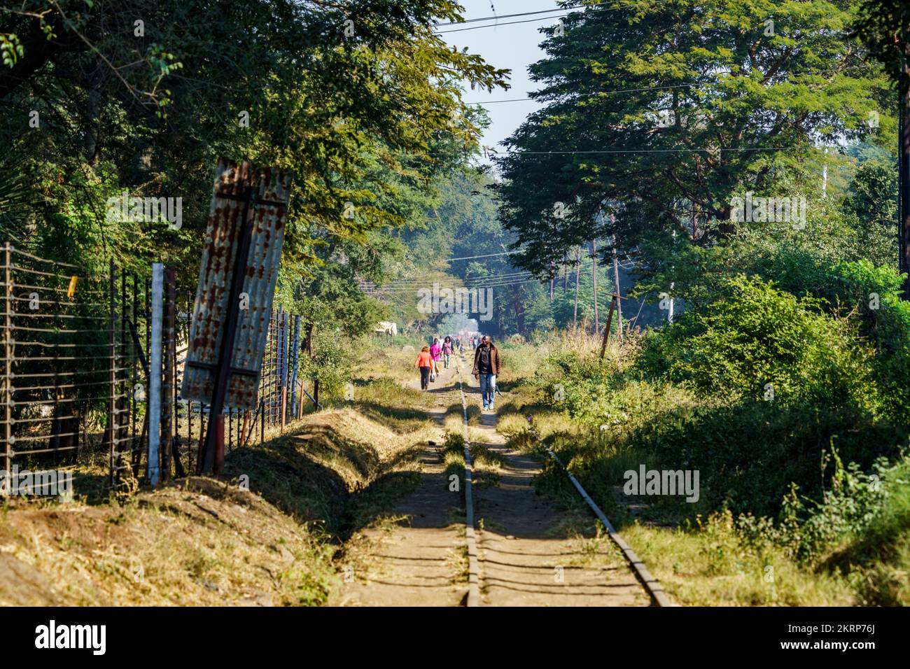 Train tracks, African people walk in the middle of the railway. Railroad of the Royal Express in Livingstone. Livingstone, Zambia Stock Photo