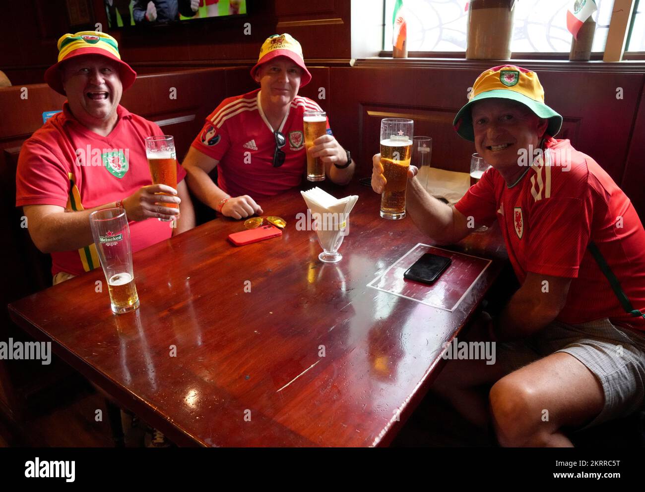 Wales fans Tony Rodgers (left), Mike Gristwood (centre) and Steve Pope (right) in the Red Lion Pub & Restaurant in Doha, Qatar, on the day of the FIFA World Cup Group B match between Wales and England. Picture date: Tuesday November 29, 2022. Stock Photo