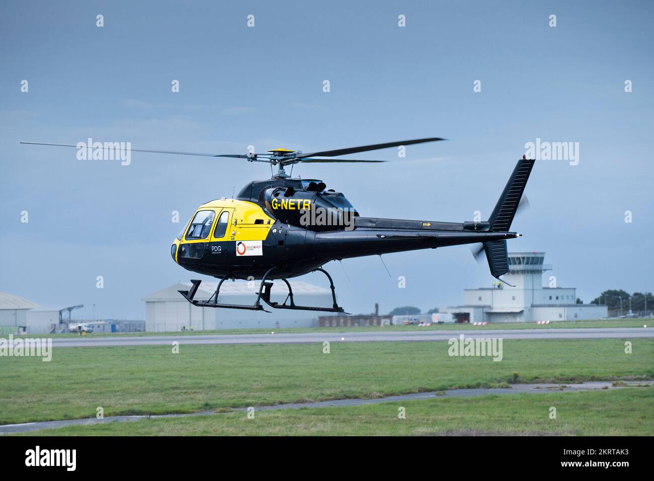 A Eurocopter AS355 F1 G-NETR PDG Aviation Services helicopter landing at Newquay Airport in Cornwall in the UK. Stock Photo