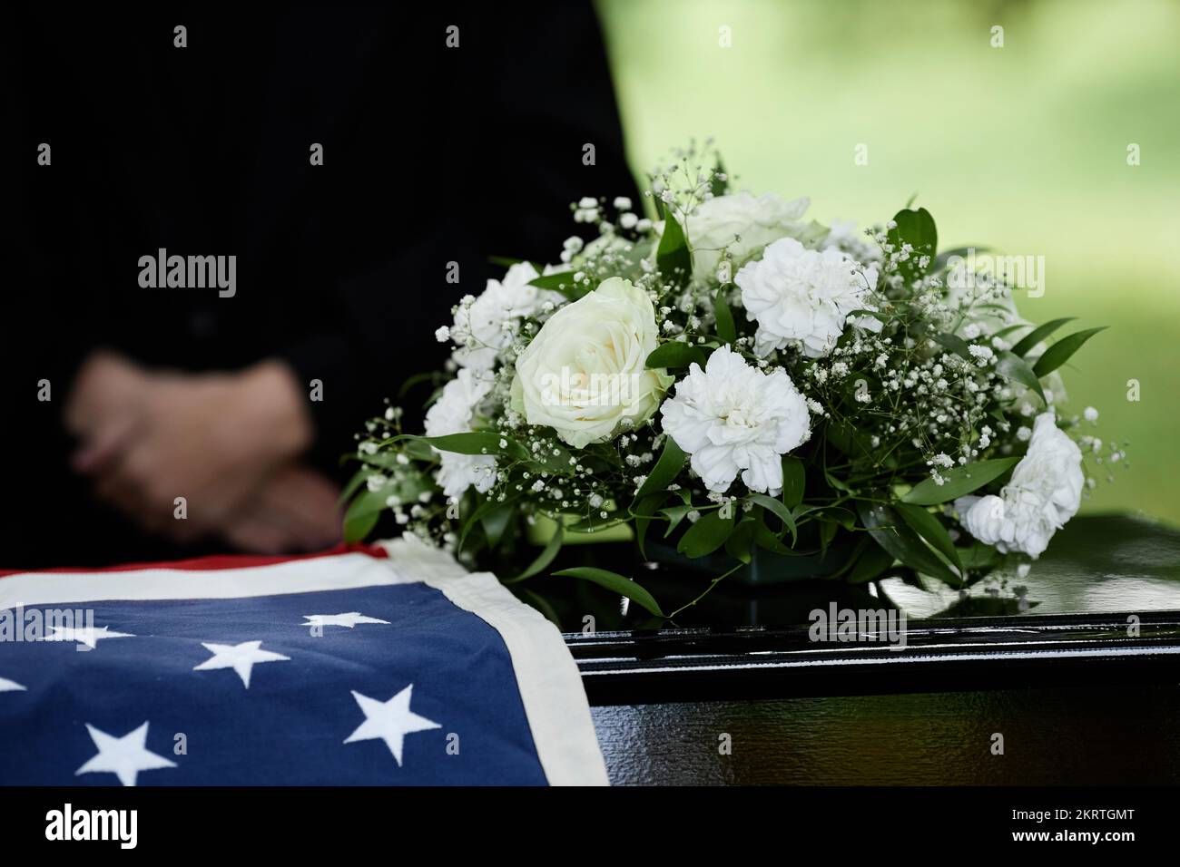 Closeup of coffin with flowers at outdoor funeral ceremony for army
