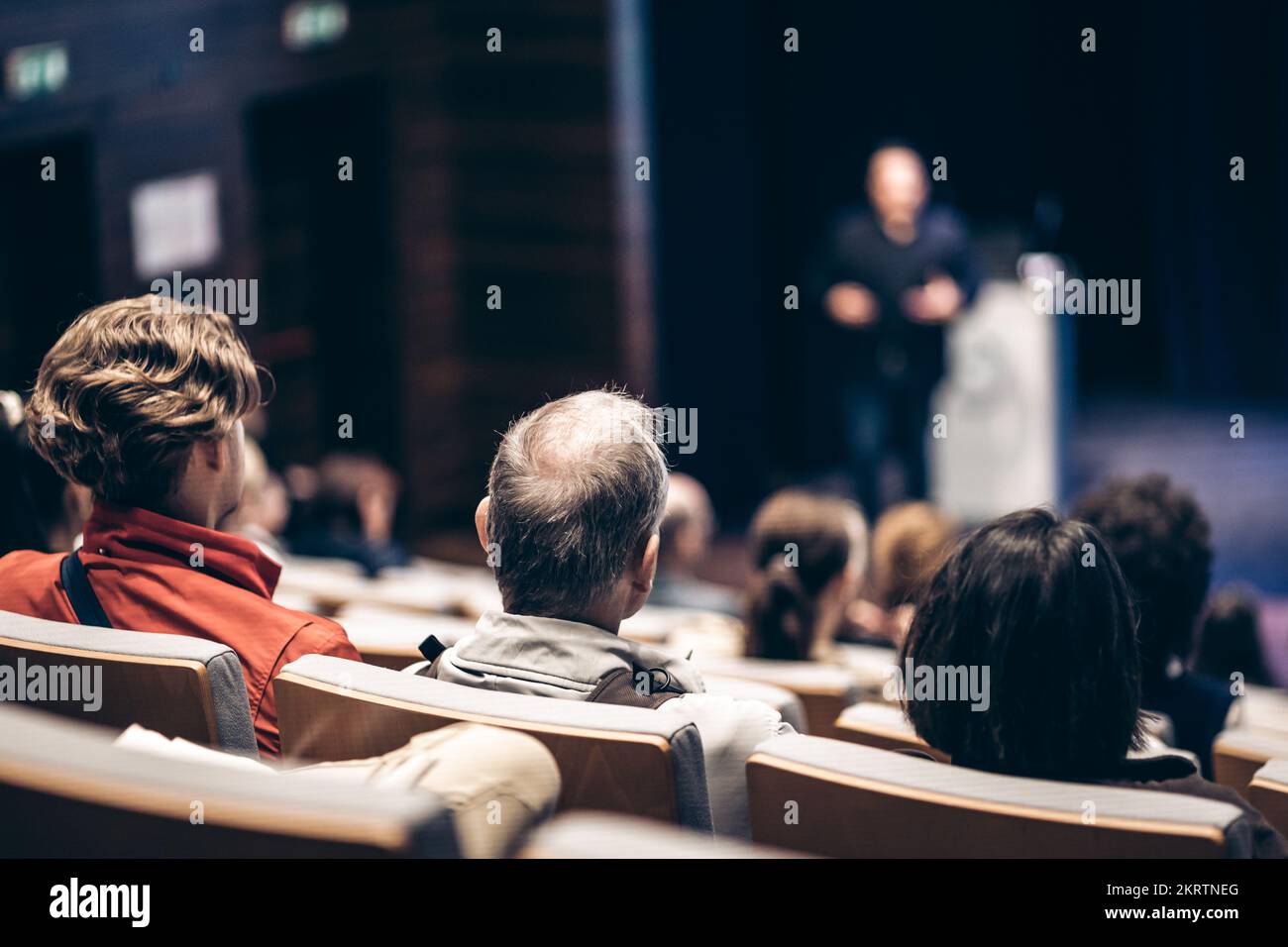 Speaker giving a talk in conference hall at business event. Rear view of unrecognizable people in audience at the conference hall. Business and entrep Stock Photo