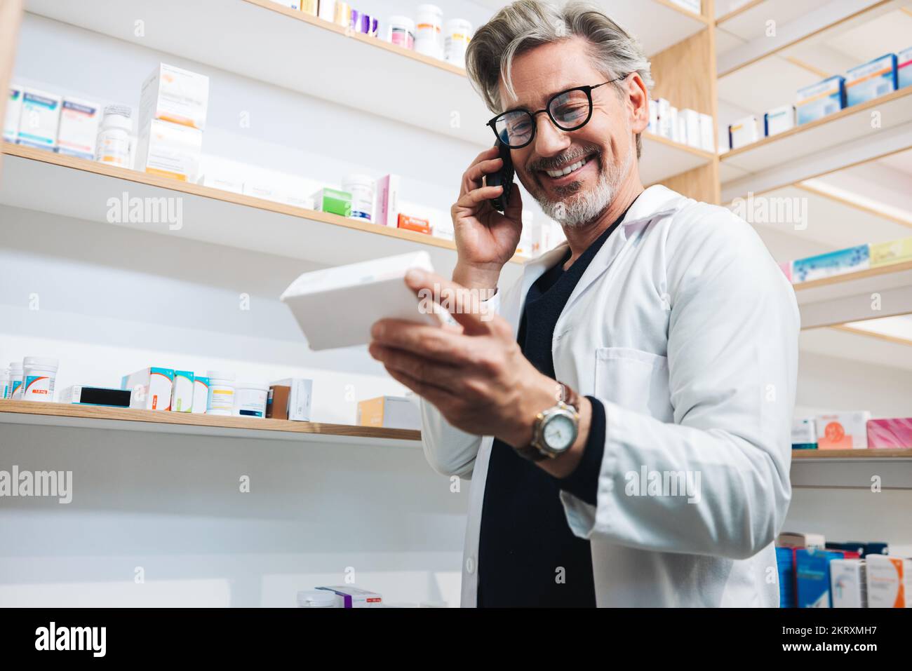 Pharmacist reading a medication label while talking to a patient on the