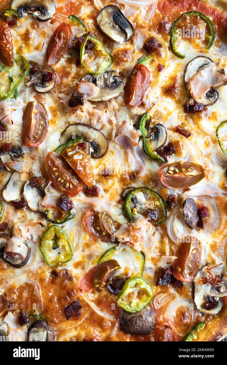 Very close shot of a freshly made green pepper, onion, mushroom, cherry