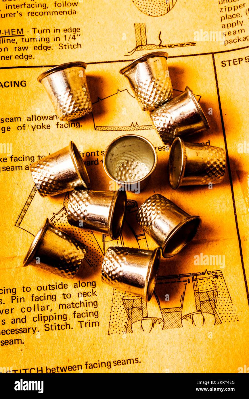 Old sewing art on a thimble collection tailored to a cross stitch guide. Patterns and thimbles