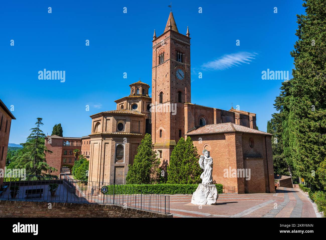 Benedictine Abbey of Monte Oliveto Maggiore, with white marble statue of Saint Benedict in foreground, Province of Siena, Tuscany, Italy Stock Photo