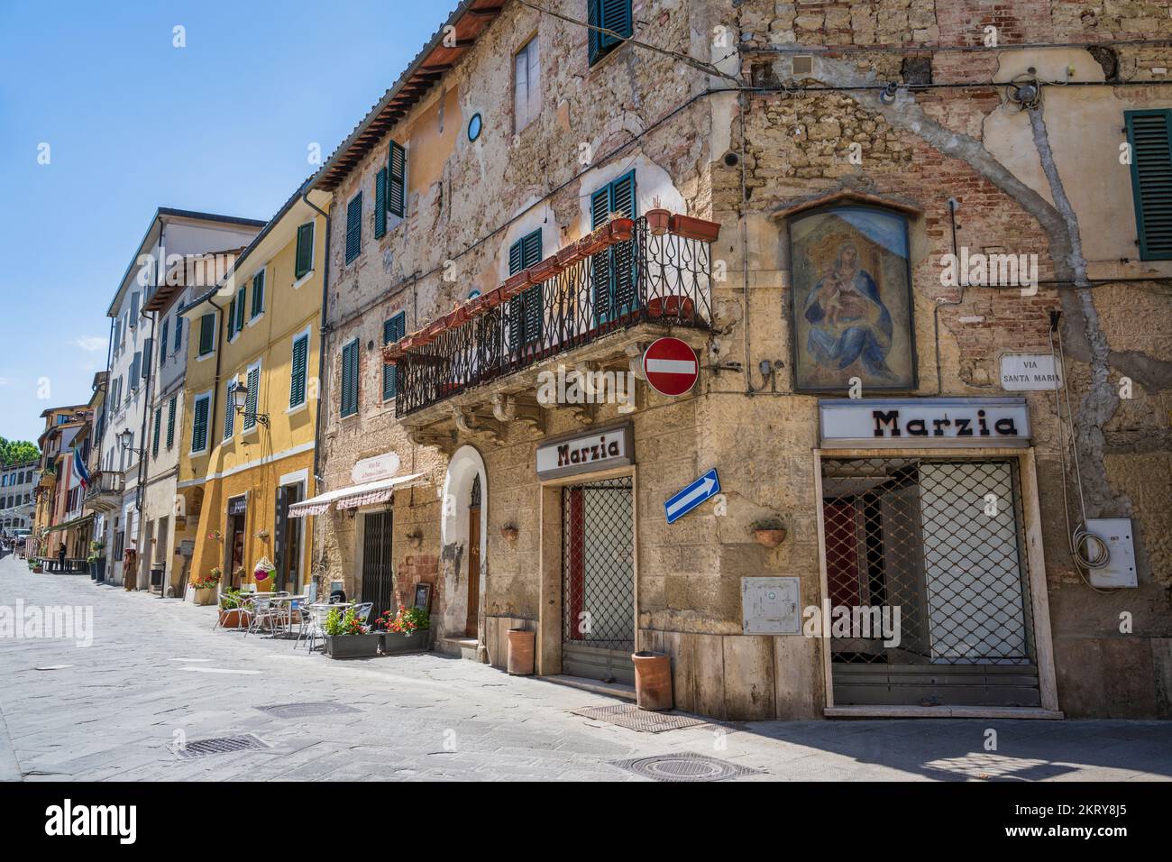 Shops and cafes on Corso Giacomo Matteotti in the medieval town of Asciano in the Crete Senesi, Province of Siena, Tuscany, Italy Stock Photo