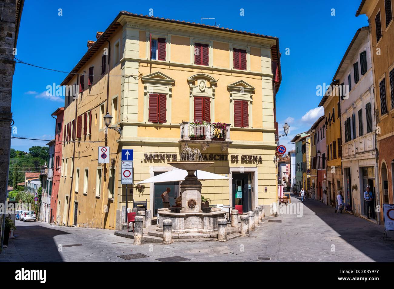 Fountain at junction of Corso Giacomo Matteotti and Via Bartolenga in medieval town of Asciano in the Crete Senesi, Province of Siena, Tuscany, Italy Stock Photo