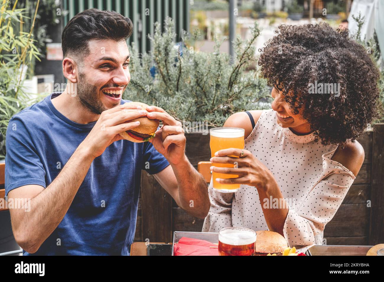 young couple having fun at restaurant, two diverse friends eating