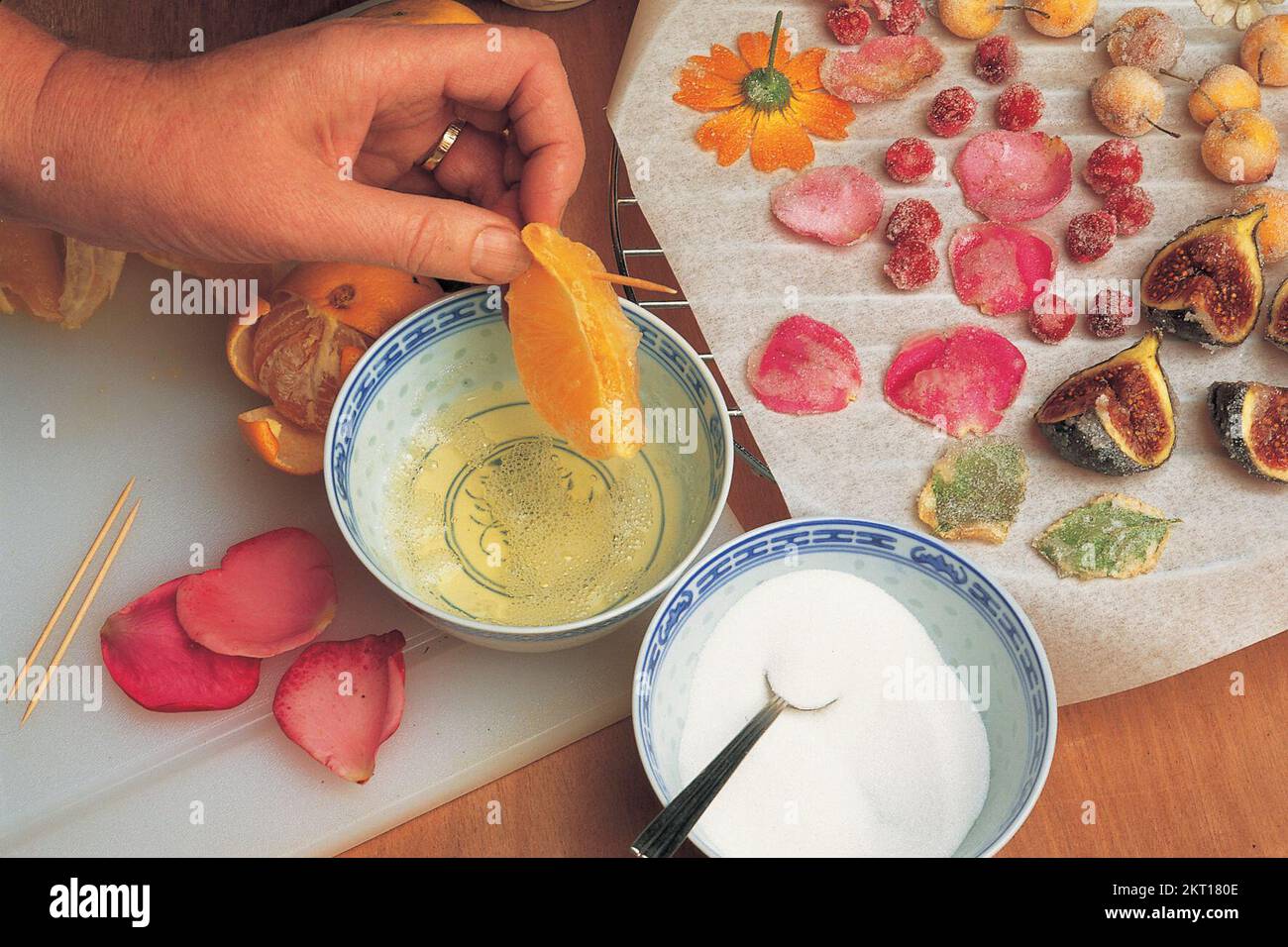Dipping an orange segment into egg yolk Stock Photo