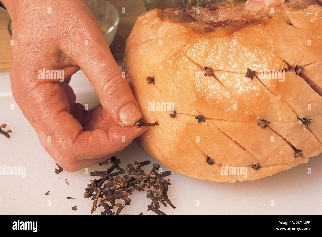 Inserting cloves into the meat joint Stock Photo