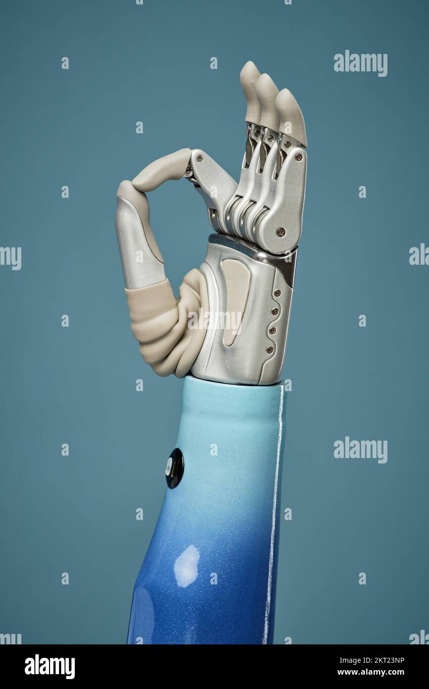 High-Tech prosthesis showing OK sign against blue background Stock Photo