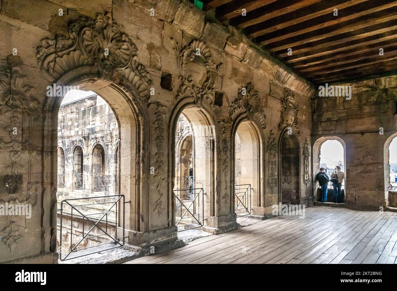 Nice view inside a room with a wooden floor, wooden beam ceiling and Baroque reliefs carved out of the sandstone wall of the famous Porta Nigra, a... Stock Photo