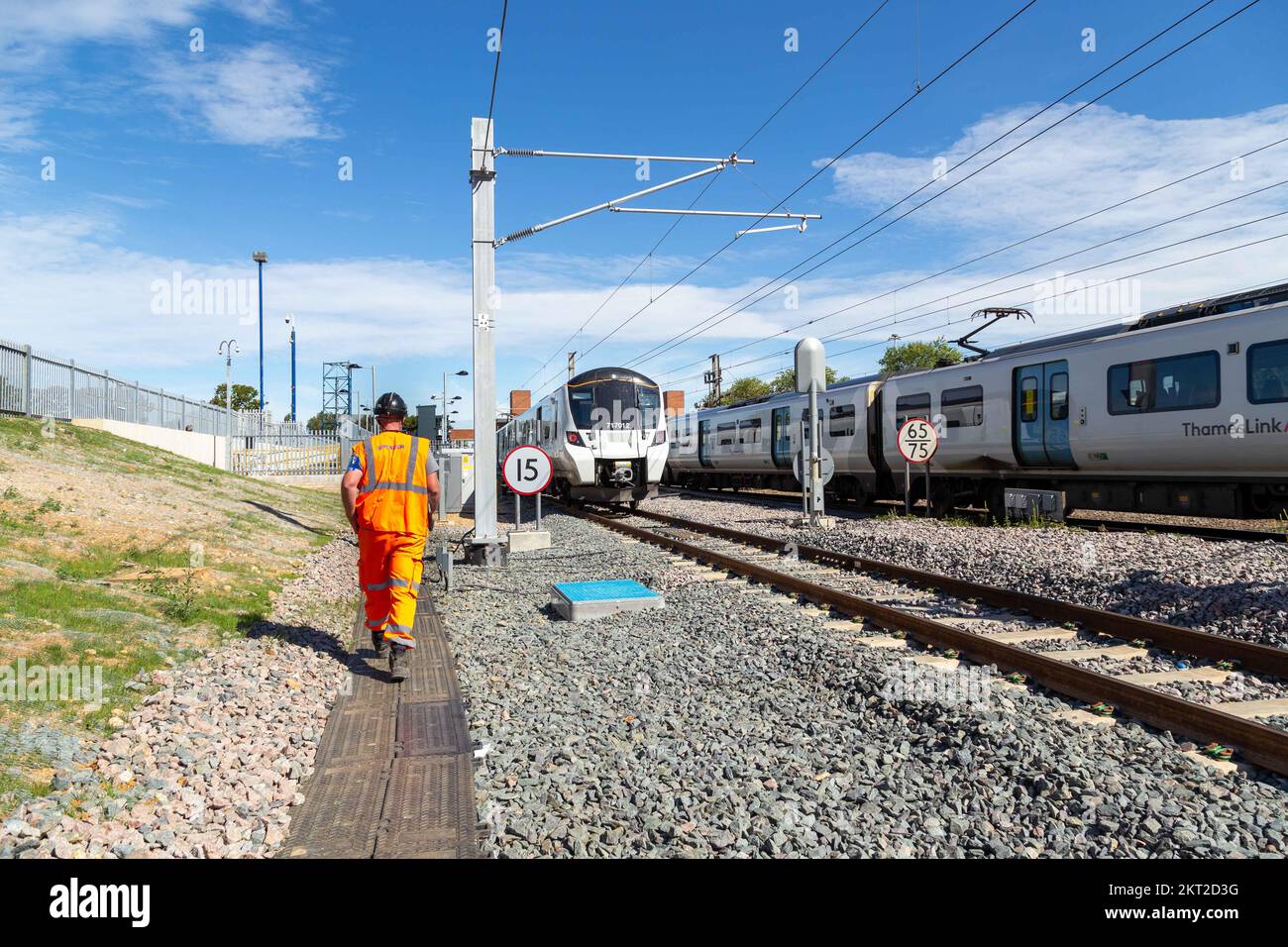 Railway worker inspecting sidings on new railway track with trains Stock Photo
