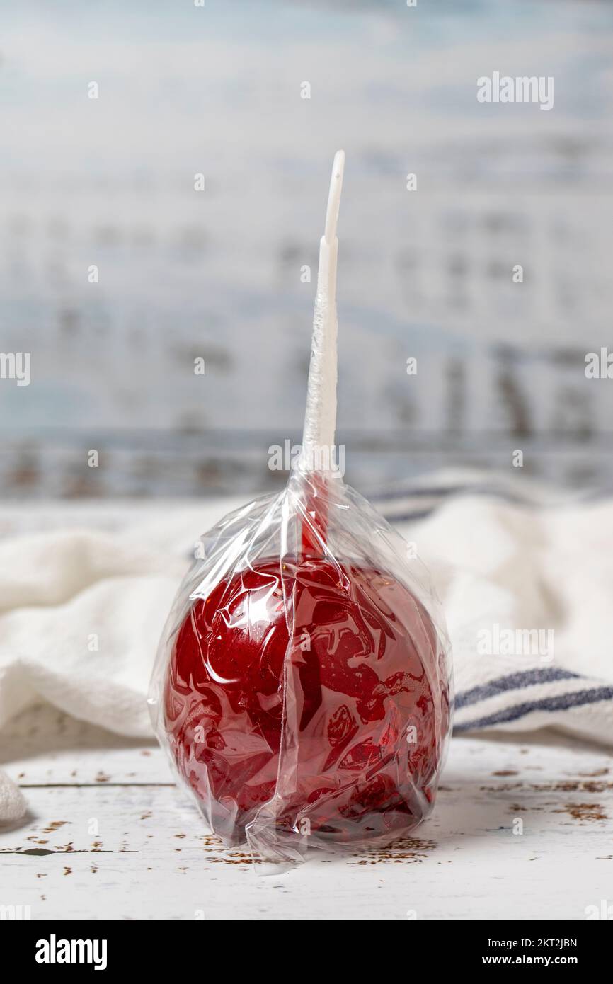 Apple candy or red toffee. Candy apples with syrup on a white wood background. close up Stock Photo