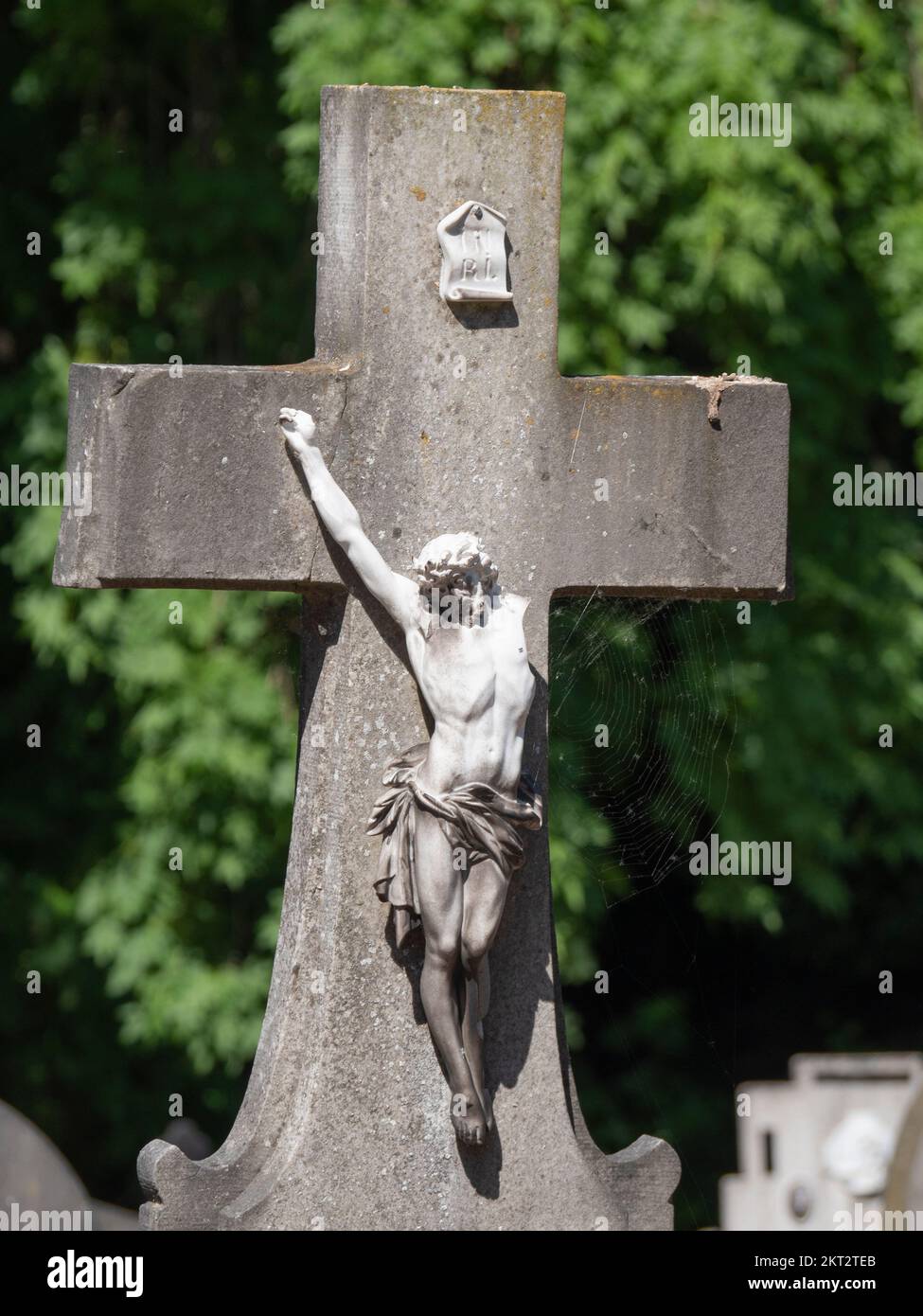 photo of a white broken statue of Jesus Christ on a concrete cross Stock Photo