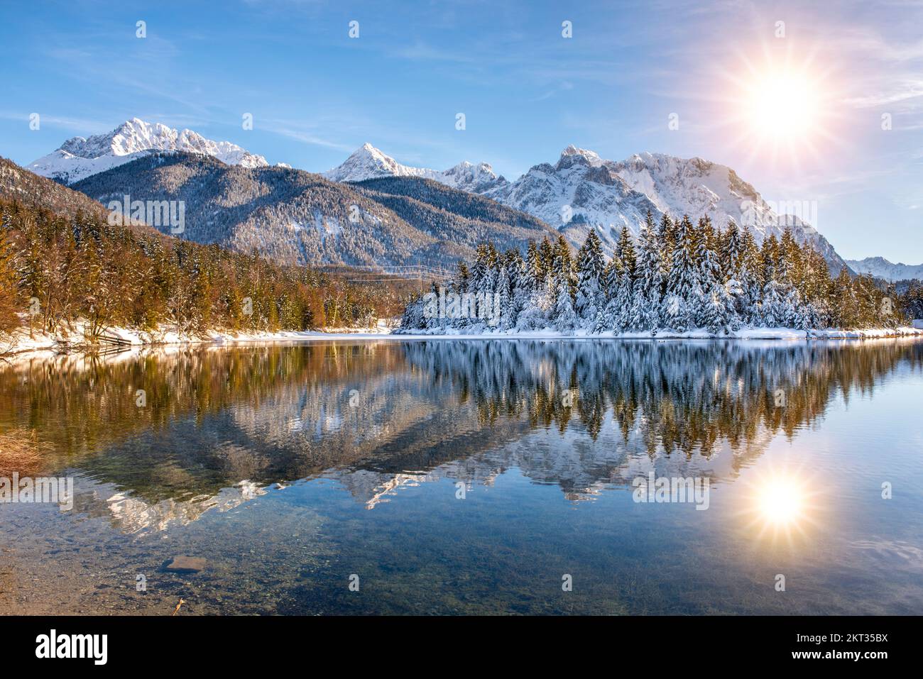 calm panoramic winter landscape with snow, mountain range and reflection in lake Stock Photo