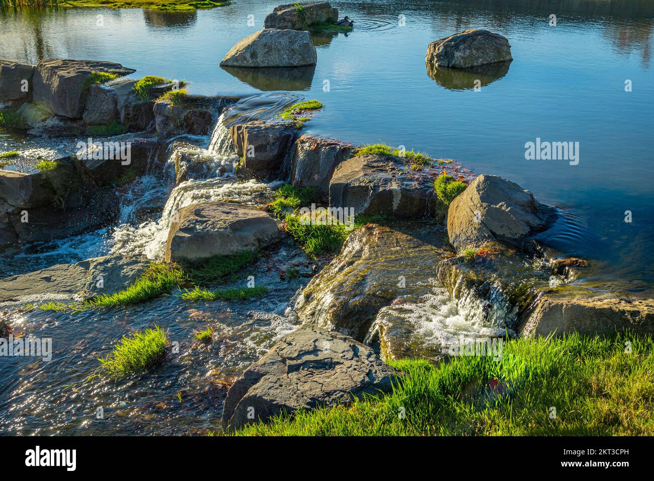 Water from small pond trickling over rocks down stream, Pennsylvania USA Stock Photo
