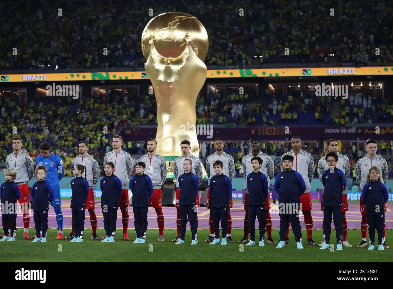 28th November 2022; Stadium 974, Doha, Qatar; FIFA World Cup Football, Brazil versus Switzerland; Switzerland starting eleven with a giant FIFA World Cup trophy behind the team Stock Photo