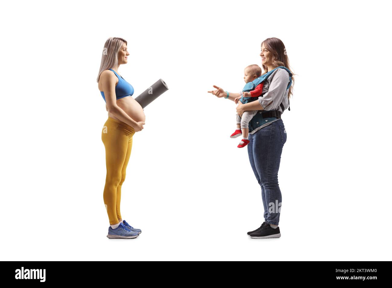 profile shot of a pregnant woman in sportswear with an exercise mat having a conversation with a mother and baby isolated on white background Stock Photo