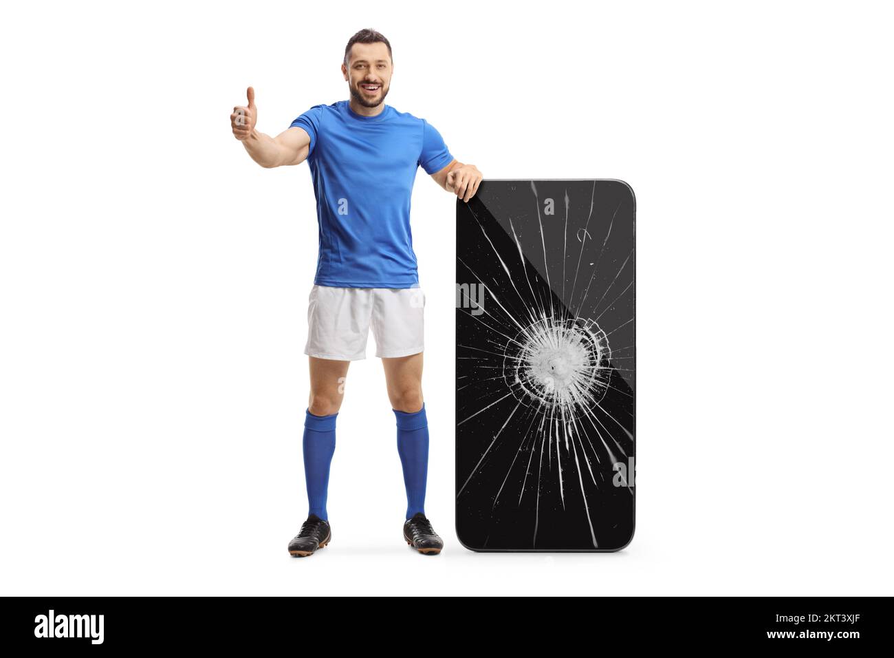 Full length portrait of a football player gesturing thumbs up next to a smartphone with broken screen isolated on white background Stock Photo