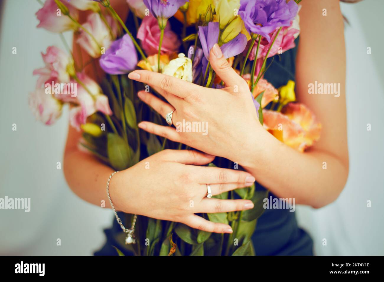 Women's hands hold flowers in their hands. Girl in jewelry, rings and bracelet. Bouquet for a woman on a holiday on February 14, March 8 Stock Photo