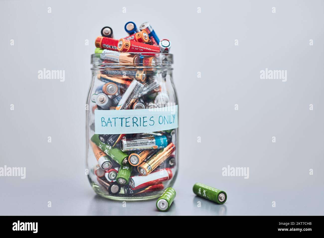 Jar filled with discharged used batteries. Waste disposal and recycling