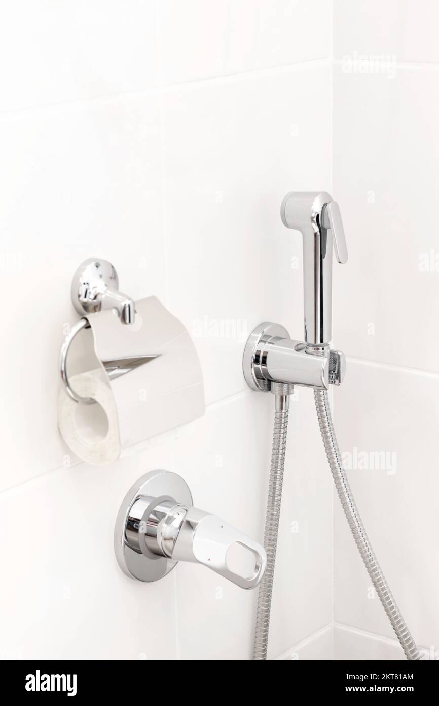 https://c8.alamy.com/comp/2KT81AM/details-in-a-bright-modern-bathroom-toilet-paper-holder-hygienic-shower-2KT81AM.jpg