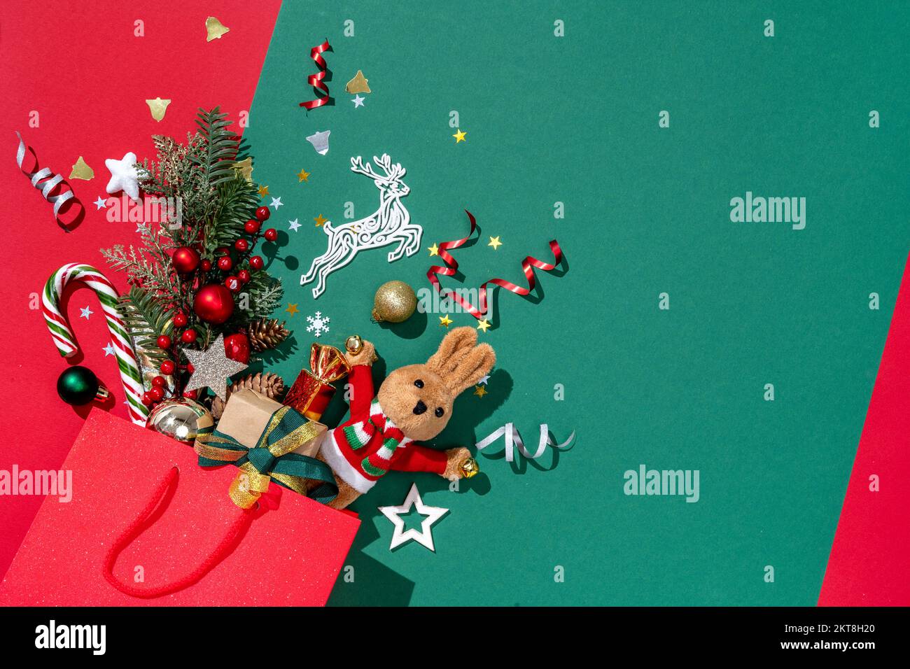 Holiday explosion from shopping bag on green background. Merry Christmas and Happy New Year concept Stock Photo