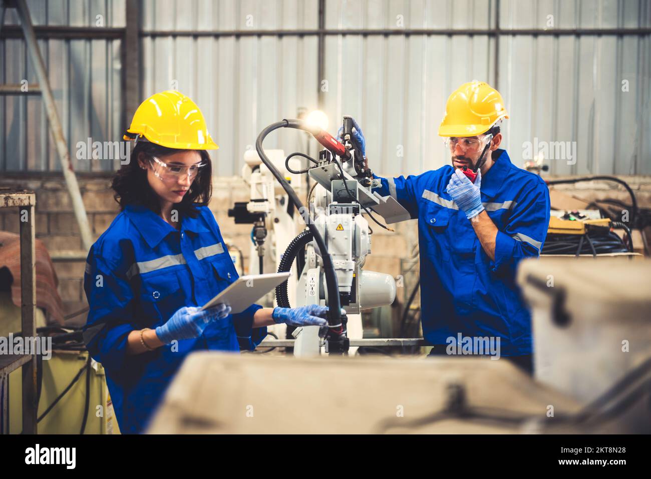 Two engineers mechanic using computer controller Robotic arm for ...
