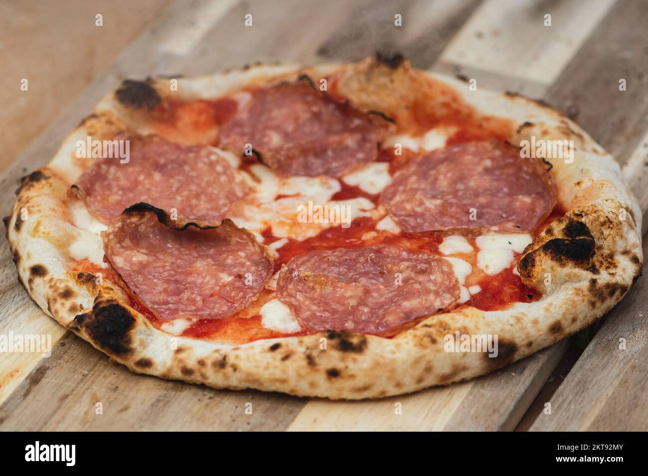 Hot pizza ready to eat with tomato sauce, mozzarella and salami meat on